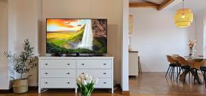 a living room with a tv on top of a dresser at Apartment Bluemare B6 with Shared Pool in Ližnjan
