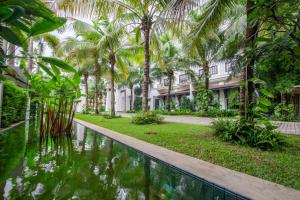un complejo con piscina frente a un edificio en THE PRIVILEGE FLOOR by Lotus Blanc, en Siem Reap