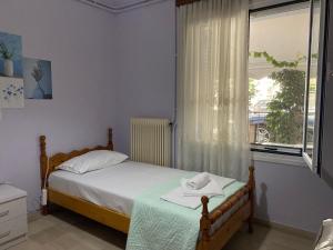 a small bedroom with a bed and a window at Family house near Lefkada in Vonitsa