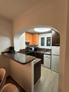 una gran cocina con un arco en una habitación en OLIVA NOVA GOLF BEACH & RESORT Club Sevilla VI 3A, en Oliva