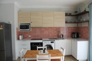 a kitchen with a table and a stove and a microwave at Spacious Modern Acreage Getaway- close to Shopping mall in Browns Plains
