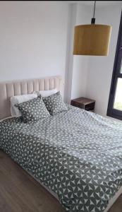 a bedroom with a bed with a black and white comforter at Time suits with beautiful view and pool in Valencia