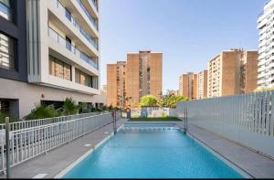 a swimming pool in a city with tall buildings at Time suits with beautiful view and pool in Valencia