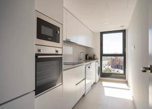 a kitchen with white appliances and a window at Time suits with beautiful view and pool in Valencia