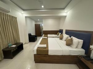 a hotel room with two beds and a desk at JN Guestline in Devanahalli-Bangalore