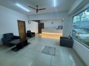sala de estar con 2 sillas, mesa y ventana en JN Guestline en Devanahalli-Bangalore