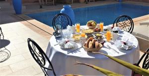 a white table with food on it next to a pool at Jenny Lynn in Marrakech