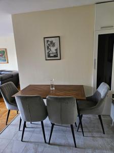 Un comedor con mesa y sillas de madera. en Alex&Buba (FREE private parking), en Belgrado