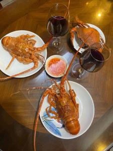 une table avec deux assiettes de homards et des verres de vin dans l'établissement Casablanca Hotel Thanh Hóa, à Thanh Hóa