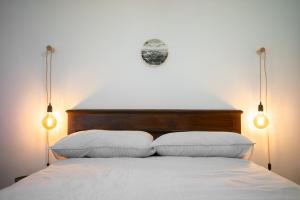 a bedroom with a bed with two pillows and two lights at Materin in Roccaforte Mondovì