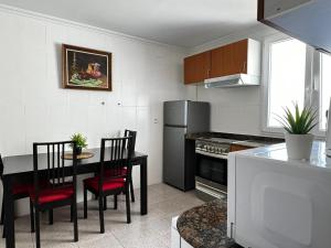 cocina con mesa, sillas y nevera en Grandera Apart`s - Assutzena 5, en Valencia