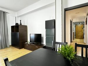 sala de estar con mesa negra y cocina en Grandera Apart`s - Assutzena 5, en Valencia