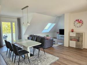 a dining room and living room with a table and chairs at FeWo Nahner Loft in Osnabrück