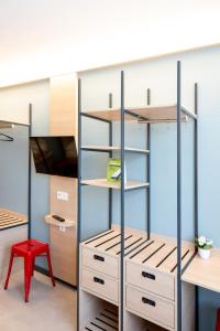 a room with shelves and a red chair at Sportcampus Saar in Saarbrücken