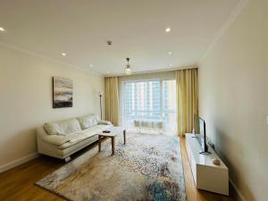 Una sala de estar con un sofá y un televisor. en City Apartment Home, en Ulán Bator