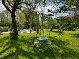 einen Tisch und zwei Stühle in einem Garten mit einem Baum in der Unterkunft chambre d'hôte la Sourdrie in Saint-Florent-le-Vieil