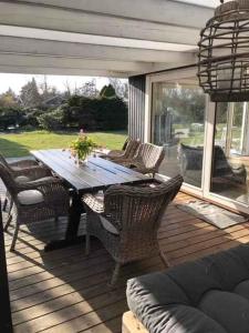 a wooden deck with a wooden table and chairs at Lovely Holiday Home With Annex And Garden, in Dronningmølle