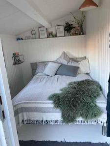 a bed with a green furry blanket on it at Lovely Holiday Home With Annex And Garden, in Dronningmølle