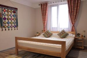 a bedroom with a bed and a window with curtains at Salamat Hotel in Bishkek