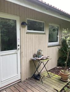 ein Haus mit einer Tür und einem Tisch mit einem Kuchen darauf in der Unterkunft Lovely Summer House By The Coast, in Præstø