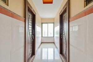 a hallway with two doors and a window at SPOT ON Hotel Sai Jeeva Residency in Shirdi