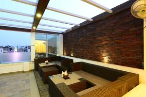 a living room with a couch and a brick wall at Hotel City Star, Near Connaught Place & New Delhi Railway Station, with Free Airport Pickup in New Delhi