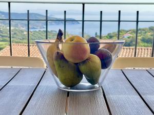 a glass bowl of fruit sitting on a table at Appartamento Blu Relax in Capoliveri
