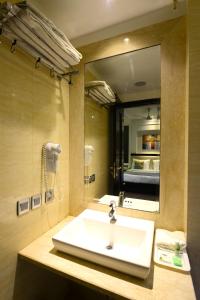 bagno con lavandino e grande specchio di Hotel City Star a Nuova Delhi