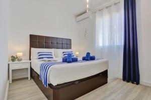 a bedroom with a large bed with blue pillows at Neptuno Bungalows - Adults Only in Corralejo +25 photos