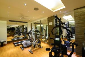 a gym with several treadmills and elliptical machines at Hotel City Star in New Delhi