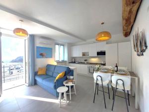 a living room with a blue couch and a kitchen at Vichi's nest in Pianello Del Lario