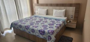 a bedroom with a bed with a floral bedspread at Shree Jee Homestay in Vrindāvan