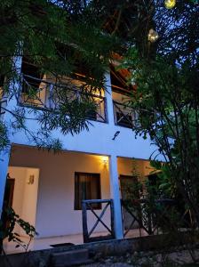 SECRET PLACE HOTEL by HELLO TANZANIA TOURS& SAFARIS في Makunduchi: مبنى ابيض امامه اشجار