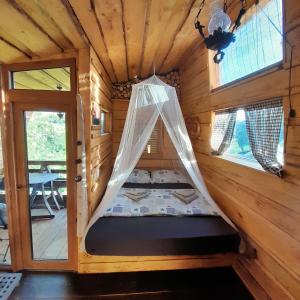a bed in a log cabin with a window at Glamping pod Hrastom in Dramlje