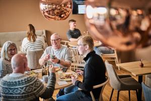 um grupo de pessoas sentadas em torno de uma mesa em um restaurante em Smarthotel Forus em Stavanger