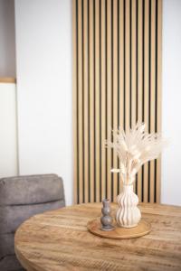 GillenfeldにあるFerienanlage Villa Maareの羽の花瓶付き木製テーブル