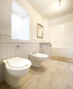 ein weißes Badezimmer mit Toilette und Waschbecken in der Unterkunft Sculpture Park Cottage in Penistone + 20 Fotos