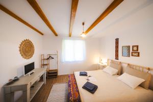 Un dormitorio con una cama, un escritorio y un televisor. en CASA LILA, en Colţi