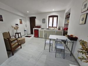 Una cocina y una sala de estar con mesa y sillas. en Casa Pisani 19, en Iglesias