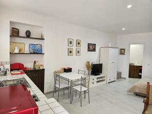 Una sala de estar con una mesa y un refrigerador. en Casa Pisani 19, en Iglesias