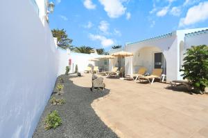 a patio of a house with chairs and umbrellas at Neptuno Bungalows - Adults Only in Corralejo
