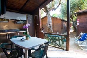 a white table and chairs on a patio with a kitchen at Villaggio Camping Esca in Marina di Camerota