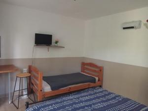 a small bedroom with a bed and a tv at Berbi Rosse in Oletta