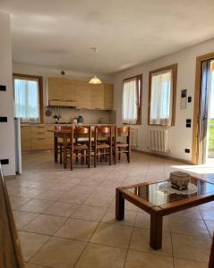 cocina y sala de estar con mesa y sillas en Casa dei Prati, en Brendola