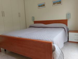- une chambre avec un grand lit et un cadre en bois dans l'établissement agriturismo I Gelsi Marina di Grosseto, à Marina di Grosseto