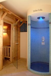 Habitación con baño con ducha grande de color azul. en Hotel Roy, en Malga Ciapela