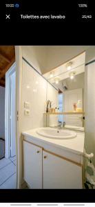 een witte badkamer met een wastafel en een spiegel bij Mazet 5 pers plage parking gratuit wifi clim in La Londe-les-Maures
