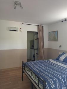 a bedroom with a bed with a blue comforter at Berbi Rosse in Oletta