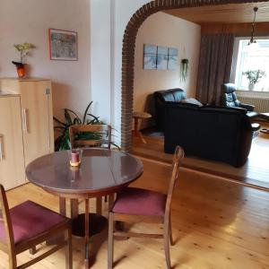 a living room with a table and chairs and a couch at Nordseeferienhaus-Alma in Niebüll