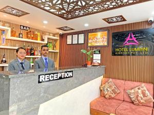 加德滿都的住宿－Hotel Lumbini Airport，两个男人站在酒店大堂的酒吧